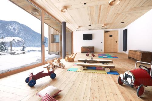 a living room with wooden furniture and a large window at Bio Aparthotel Blaslahof in Valle Di Casies