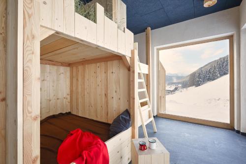a wooden bunk bed in a room with a window at Bio Aparthotel Blaslahof in Valle Di Casies
