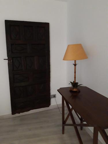 a table with a lamp on it next to a door at La Sinagoga in Peñaranda de Duero