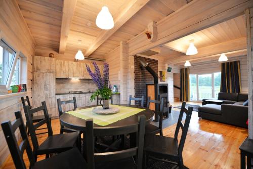 a dining room and living room with a table and chairs at Kliukai in Dubingiai