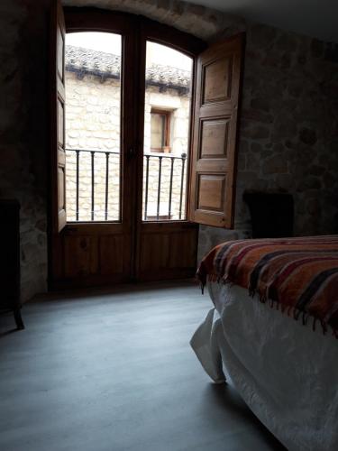a bedroom with a bed and a large window at La Sinagoga in Peñaranda de Duero