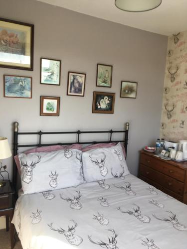 a bedroom with a bed with white sheets and pictures on the wall at Weyside House in Weymouth
