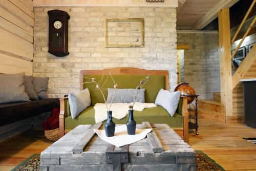 Kliukai في دوبينغياي: غرفة معيشة مع أريكة وطاولة مع مزهريات عليها