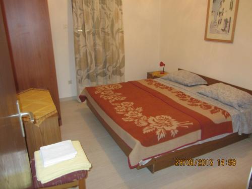 a bedroom with a bed with a red bedspread at Apartments Marisa in Mali Lošinj