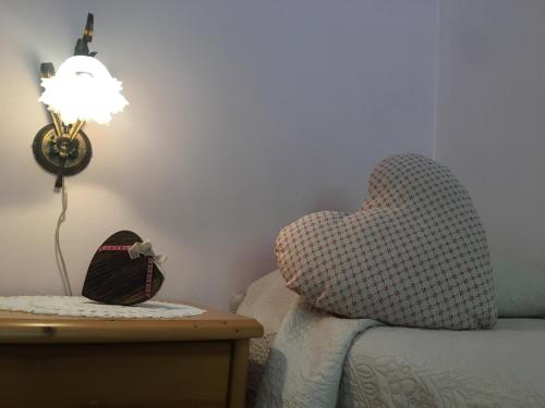 a bedroom with a bed with a heart shaped pillow at Residenza La Ciasa in Claut
