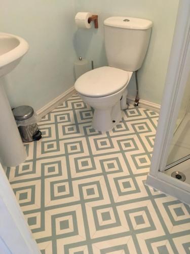 a bathroom with a toilet and a sink and a floor at Weyside House in Weymouth