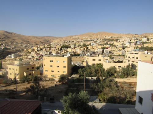 vistas a una ciudad con edificios y montañas en Juniper House, en Wadi Musa