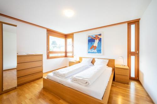 Un dormitorio con una cama grande con sábanas blancas. en LAAX Homes - Casa Miro Nr 7, en Flims