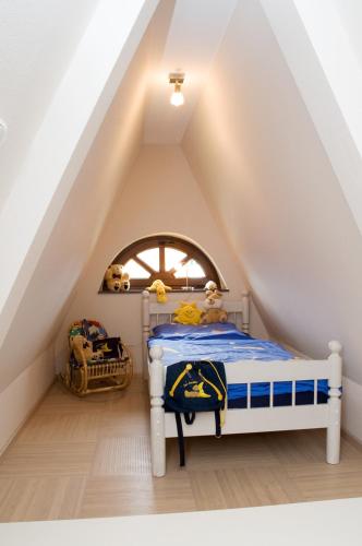 a bedroom with a white bed in a attic at Ferienwohnungen Holzmann in Buchholz Aller