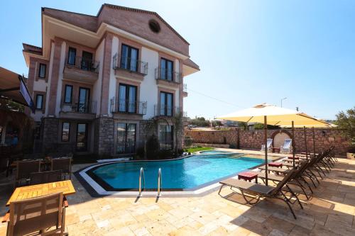 a building with a swimming pool in front of a building at Sukha Cunda Otel in Cunda