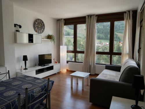 a living room with a couch and a large window at El Tarter-Vacances Pirinenca in El Tarter