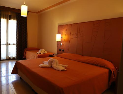 una camera d'albergo con due letti e asciugamani di SIBARI RESORT a Sibari