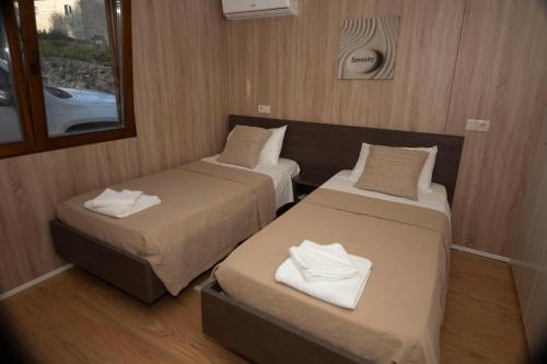 a room with two beds and a window at Quintinha do Periqueiro in Castelo do Neiva