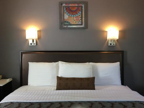 a bedroom with a bed with two lights on the wall at Scottish Inns Milford in Milford