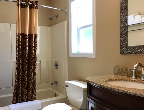 a bathroom with a sink and a toilet and a shower at Scottish Inns Milford in Milford