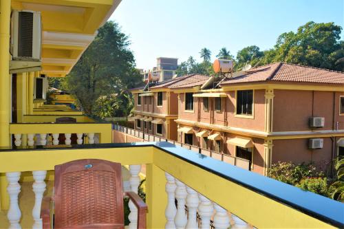 a balcony of a building with a chair on it at Sonikas Leisure in Candolim