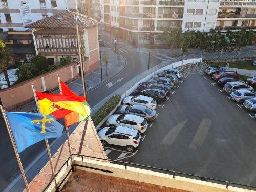 a parking lot with parked cars and a flag at Montemar in Llanes