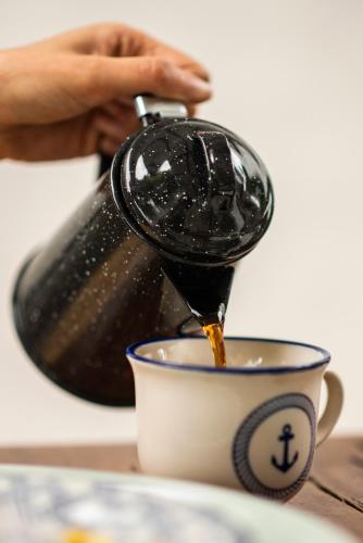 a person is pouring coffee into a cup at Casa Amberes in Honda