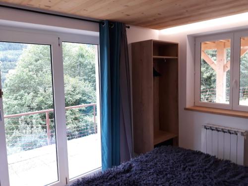 1 dormitorio con cama y ventana grande en La maison des savoyards en Husseren-Wesserling