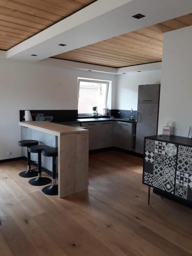 une cuisine avec une table et des chaises dans une pièce dans l'établissement La maison des savoyards, à Husseren-Wesserling