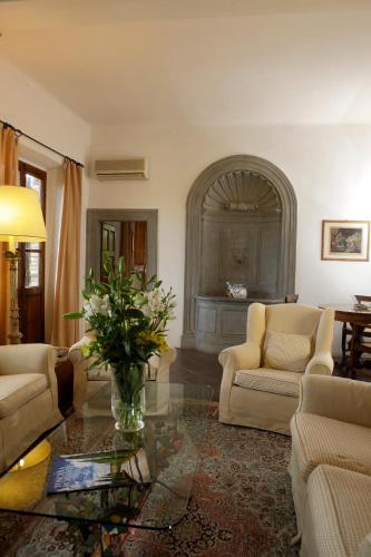 a living room with a vase of flowers on a table at Relais Vignale & Spa in Radda in Chianti