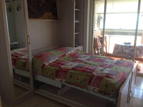 uma cama com uma colcha num quarto em MAEVA em Saint-Laurent-du-Var