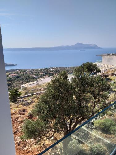 a view of the ocean and a tree on a hill at PhantΩm Villas Villa Hero in Kókkinon Khoríon