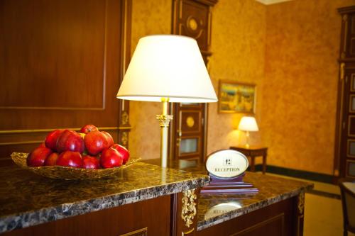 a table with a lamp and a bowl of fruit at Kainar Hotel in Shymkent