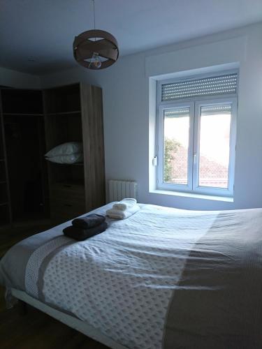 Schlafzimmer mit einem weißen Bett und einem Fenster in der Unterkunft La Ressourcerie du centre ville in Lens