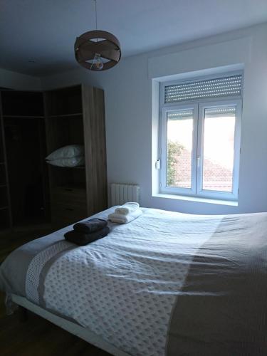 a bedroom with a white bed with a window at La Ressourcerie du centre ville in Lens
