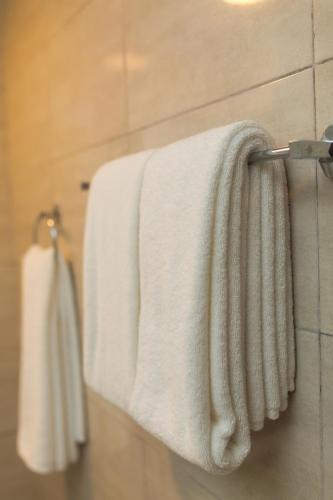 two white towels hanging on a towel rack in a bathroom at Saveira Colombo in Colombo