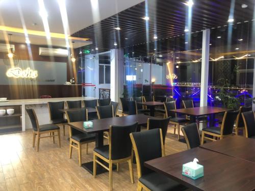 a restaurant with tables and chairs and a bar at Doha 2 Hotel Saigon Airport in Ho Chi Minh City