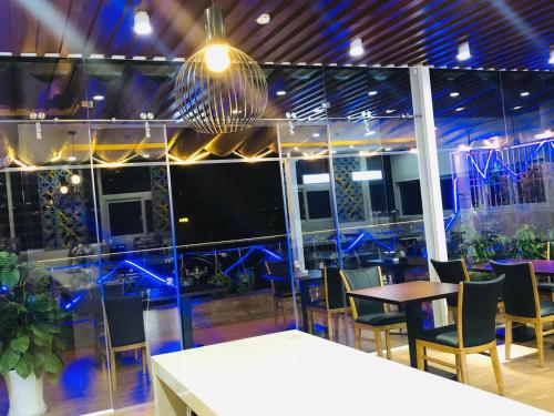a restaurant with tables and chairs and a large screen window at Doha 2 Hotel Saigon Airport in Ho Chi Minh City