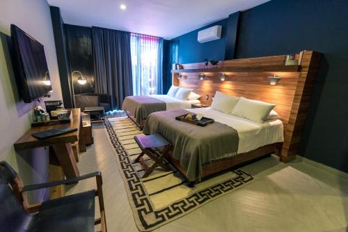 a hotel room with two beds and a television at Elena de Cobre, Leon, a Member of Design Hotels in Le&oacute;n
