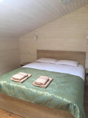 een slaapkamer met een bed met twee handdoeken erop bij Котедж Аквамарин in Jaremtsje