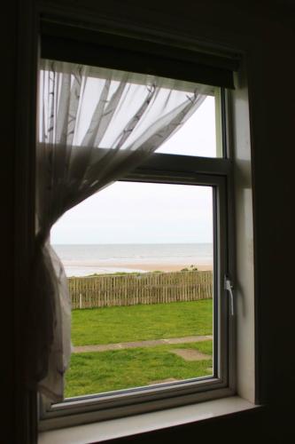 a window with a view of the ocean through it at Argyle Lodge in Rush