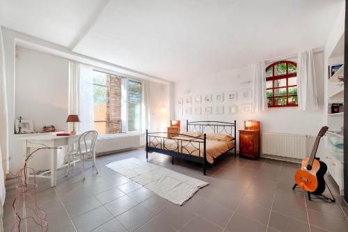 a bedroom with a bed and a desk and a guitar at Apartments Mediteraneo in Zaboric