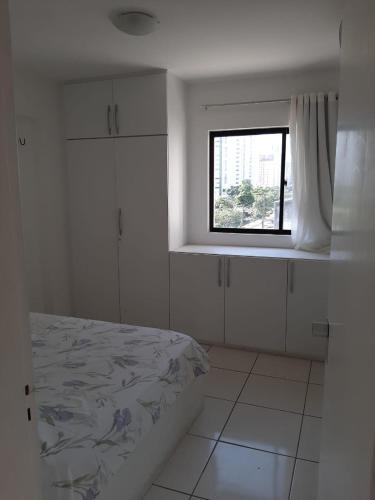 a white room with a bed and a window at Park Way Home Service in Recife