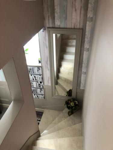 a stairway with a large mirror in a room at Casa SM in Mennecy
