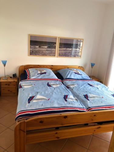 Una cama con un edredón azul con pescado. en Ferienwohnung im Haus Sommerwind en Schönberger Strand