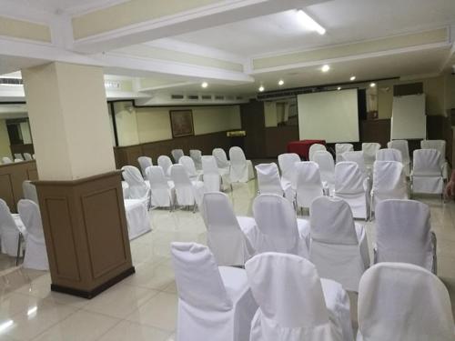 a room filled with white chairs and a podium at Hotel Ambassador in San José