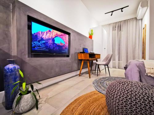EbeneにあるAvya's Studio 317, Ebene Square, Ebeneの壁に薄型テレビが取り付けられたリビングルーム