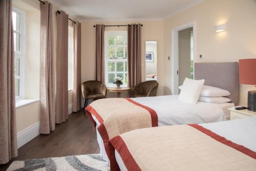 a hotel room with two beds and a window at The Garrandarragh Inn in Mullinavat