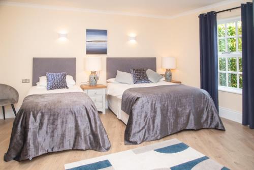 a bedroom with two beds and a window at The Garrandarragh Inn in Mullinavat