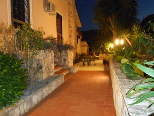 a house with a brick walkway next to a building at B&B Al Giardino in Monreale
