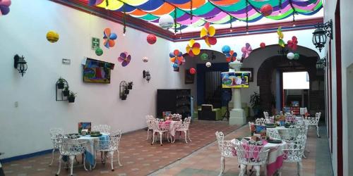 a room with tables and chairs and a wall at Hotel Aurora in Oaxaca City