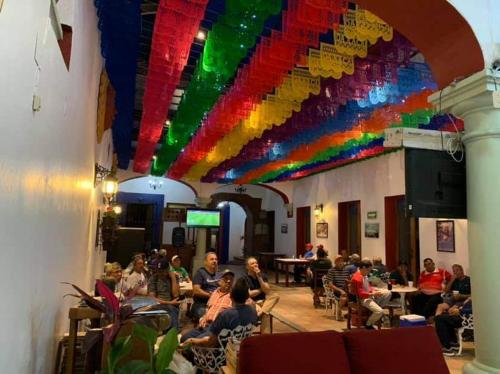 a group of people sitting in a room with a rainbow ceiling at Hotel Aurora in Oaxaca City