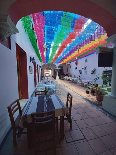 a dining room with a table and a colorful ceiling at Hotel Aurora in Oaxaca City