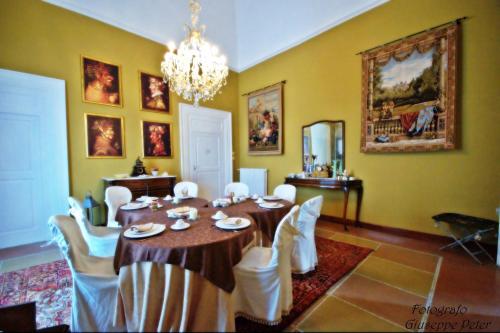 comedor con mesa, sillas y lámpara de araña en B&B Casa Cavalli en Lucera