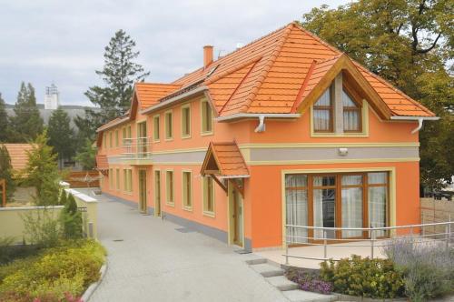 Publo Étterem és Panzió في Csákvár: منزل برتقالي مع سقف برتقالي